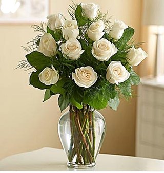 Dozen White Roses In Vase With Seasonal Greenery - $84.99